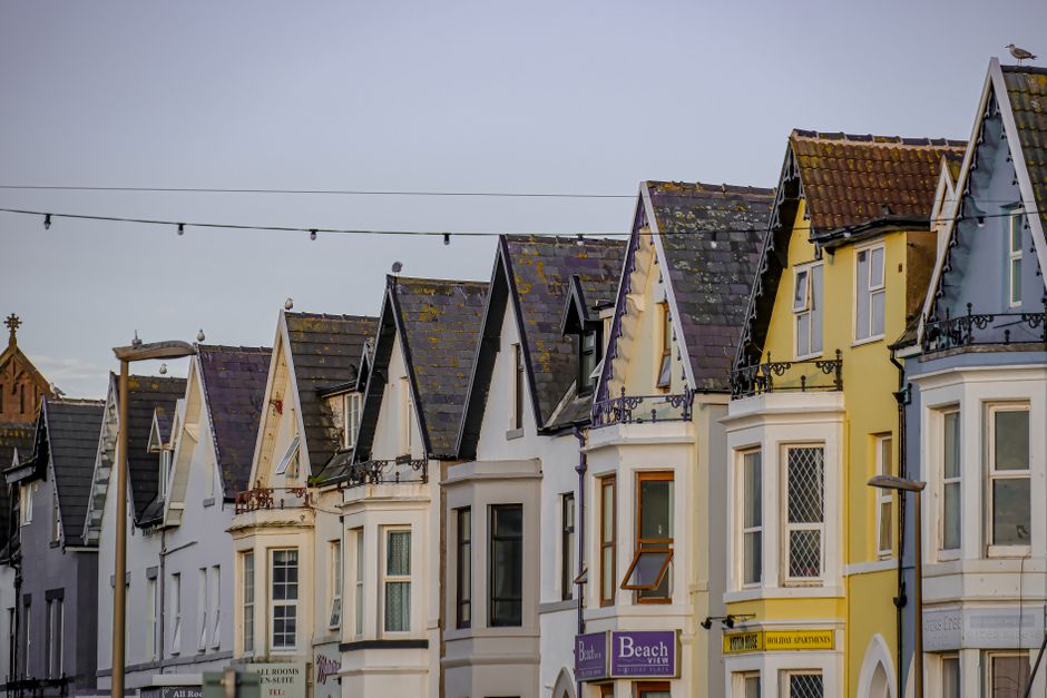 Row of colourful terraced guest houses with painted gable ends near the seafront